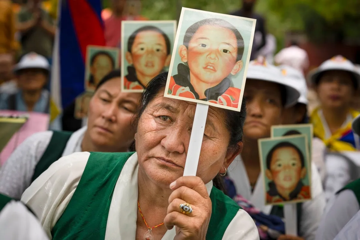 Members of the Tibetan Women's Association hold portraits of the 11th Panchen Lama